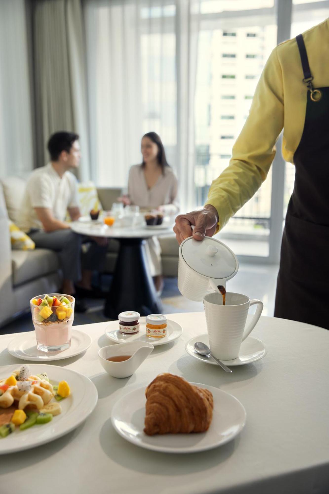 Dusit Suites Hotel Ratchadamri, Banguecoque Exterior foto A waiter serving coffee