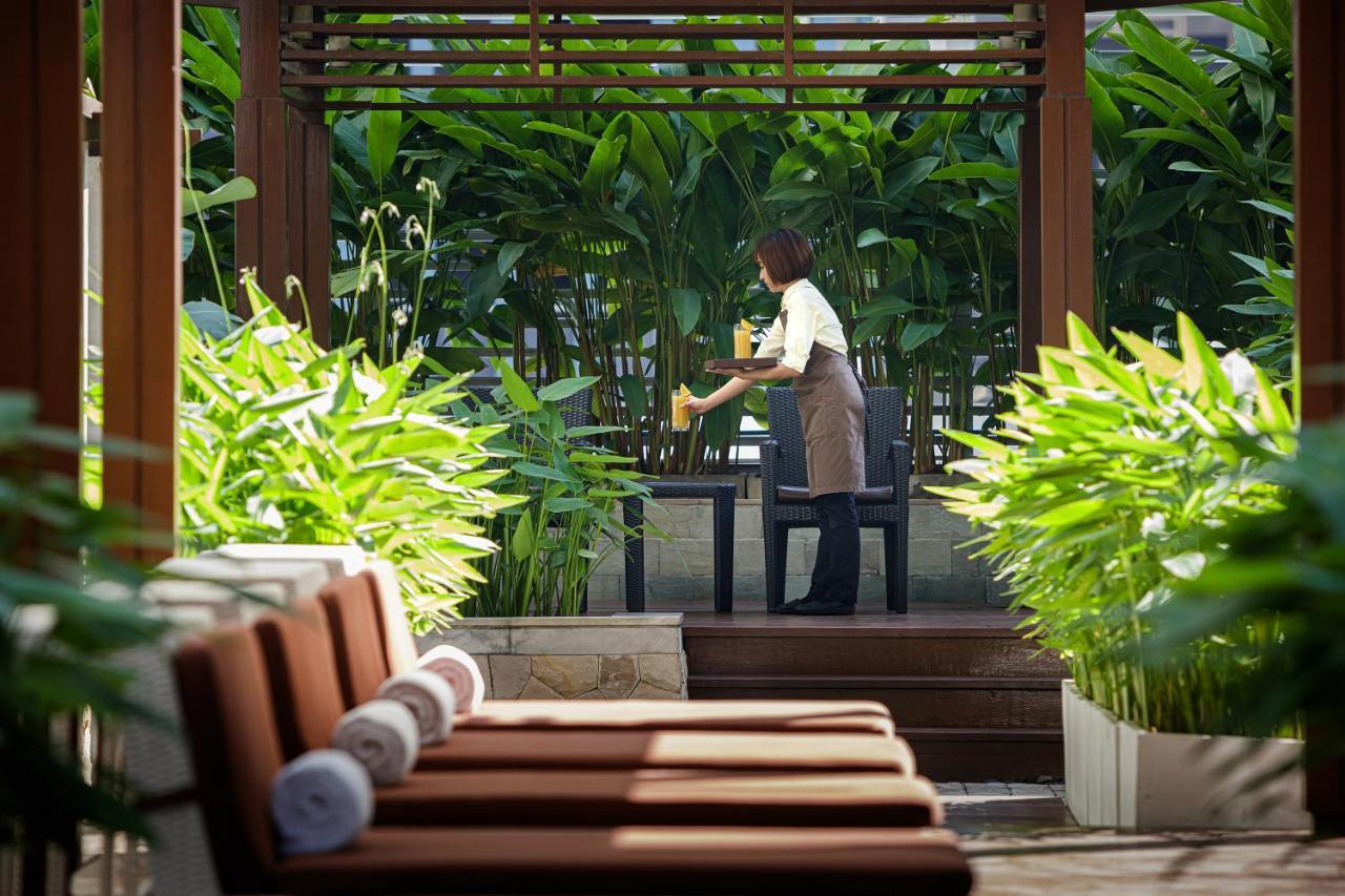 Dusit Suites Hotel Ratchadamri, Banguecoque Exterior foto A hotel staff serving drinks at a resort